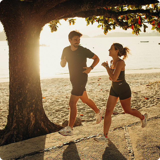Two people running outdoors on a sunny day